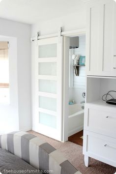 an open sliding door in a bedroom with white walls and carpeted flooring is shown