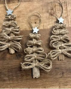 three small christmas trees made out of jute twine on a wooden table with silver stars