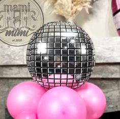 a disco ball sitting on top of pink balloons