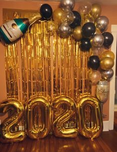 balloons and streamers are arranged around the new year's eve number balloon arch