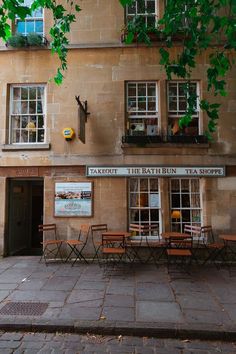 an old building with tables and chairs outside