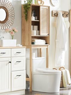 a white toilet sitting next to a wooden cabinet