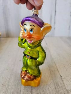 a small glass ornament with a green and yellow troll