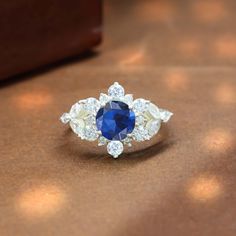 a blue and white diamond ring sitting on top of a table