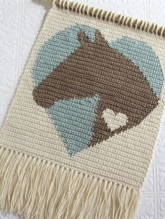 a crocheted rug with a horse on it and a heart in the center