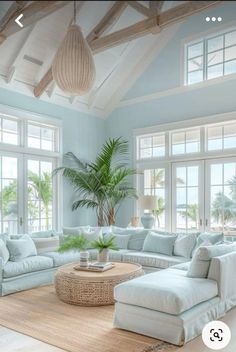 a living room filled with white furniture and lots of windows