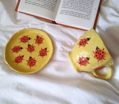 two yellow plates with ladybugs on them next to an open book