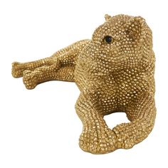 a gold colored animal statue sitting on its back with eyes wide open and legs spread out