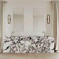 a marble bench in front of two mirrors on the wall, with curtains behind it