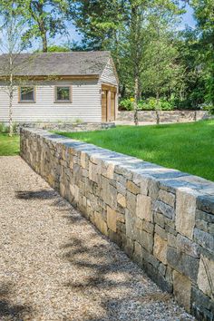 a stone wall in front of a house