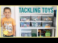 a young boy standing in front of a shelf filled with plastic containers and toy animals