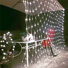 an outdoor waterproof light set up with flowers and potted plants on a table