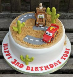 a birthday cake with cars on the top