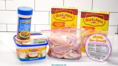 ingredients to make chicken soup laid out on a white counter with blue and yellow labels