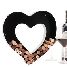 a heart shaped wine rack next to a bottle of wine and a glass of wine