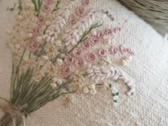 a close up of a pillow with flowers embroidered on the front and back of it