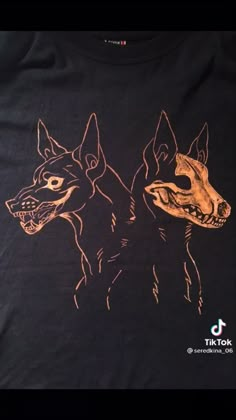 two dogs are standing next to each other on a black t - shirt with gold ink