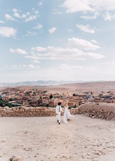 a bride and groom standing in the desert