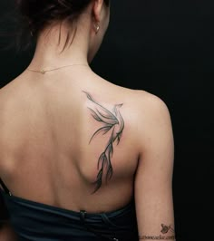 the back of a woman's shoulder with a flower tattoo on it