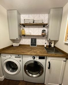 a washer and dryer in a small room with wooden counter tops on the floor