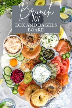 a platter filled with bagels, cucumbers, tomatoes, pickles and other foods