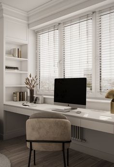 a desk with a computer on it in front of some bookshelves and windows