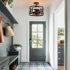 the entryway is decorated in gray and white with an intricate tile pattern on the floor