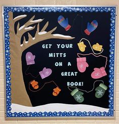 a bulletin board with mitts on a tree and snowflakes hanging from it