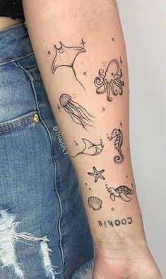 a woman with a tattoo on her arm that has various sea animals and stars in it