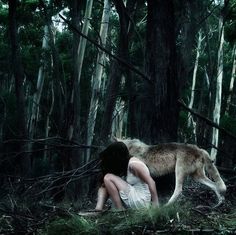 a woman kneeling down in the woods with a wolf behind her and a quote on it