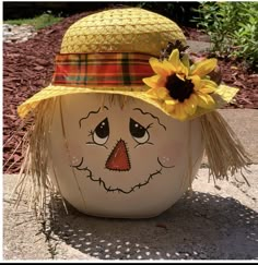 a ceramic pot with a scarecrow face and sunflowers on it's head