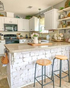 a kitchen with two stools next to an island