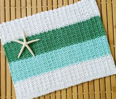 a crocheted dishcloth with a starfish on it sitting on top of a bamboo mat