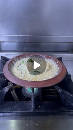 a frying pan filled with food sitting on top of an open burner oven