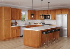 a large kitchen with wooden cabinets and white counter tops, an island in the middle