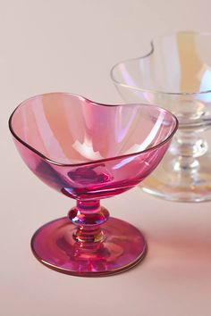 two glass bowls sitting next to each other on a table