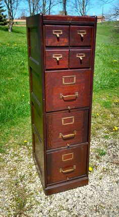 an old wooden file cabinet sitting in the grass