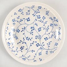 a blue and white plate with small flowers on the rim, against a gray background