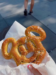 a pretzel with sesame seeds on it sitting on top of a paper bag