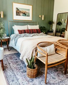 a bedroom with a bed, chair and potted plant