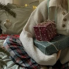 a woman sitting on a bed holding two wrapped presents