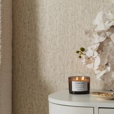 a candle sitting on top of a white table