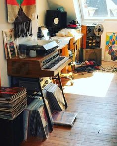 a room filled with musical equipment and lots of clutter on the floor in front of a window