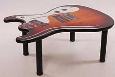 a guitar shaped table sitting on top of a white floor