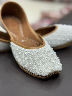 These pearl embroidered khussa's are neatly handcrafted from India ! They are super comfortable to wear with ultra-soft leather, and double cushioned sole. They are perfect for any occasion!  These pairs are hand-embroidered with pearls These shoes feature:  * pearl work * perfect for any occasion * Comfortable to wear * Double Cushioned sole   100 % Recyclable  PLEASE NOTE that these shoes are sized on standard US sizing. However, they have a snug and tight fit (as all brand new shoes usually a Wedding Ballet Flats With Closed Toe, Traditional White Slip-on Flats, White Traditional Slip-on Flats, Elegant Handwork Flats, Festive Closed Toe Ballet Flats, White Flats With Gota Work For Festive Occasion, Traditional White Closed Toe Flats, Transitional Closed Toe Wedding Shoes, White Festive Slip-on Flats