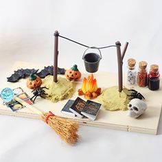 a table topped with halloween decorations on top of a wooden board next to candles and other items