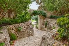 a stone path with trees and bushes on either side