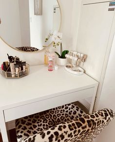 a white vanity with leopard print chair and mirror