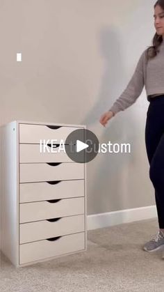 a woman standing in front of a white cabinet with five drawers and the words ikea custom written on it