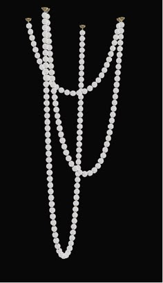 three strand pearl necklace on a black background